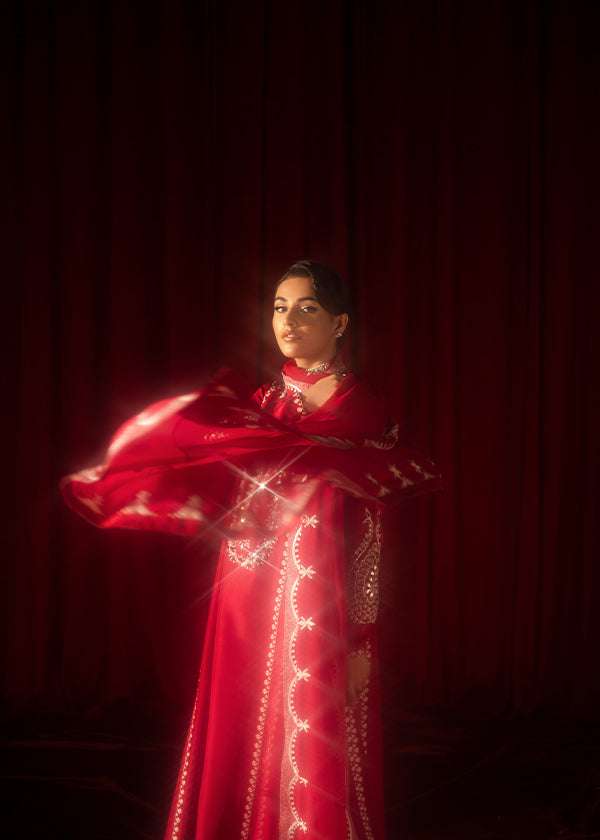 Buy Pink-Mavis raw silk kalidar dress online, featuring hand-embellished red & silver crystals, dabka work, scalloped hemline, embroidered chiffon dupatta, and tailored cigarette pants.