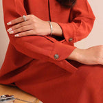 Carnelian rust raw silk suit with subtle pleats and a flowy silhouette