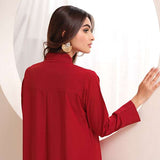 Crimson crepe suit with V-neck and minimalist stitching, exuding understated luxury.
