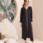 Black onyx crepe suit with white loop-button detailing and straight pants