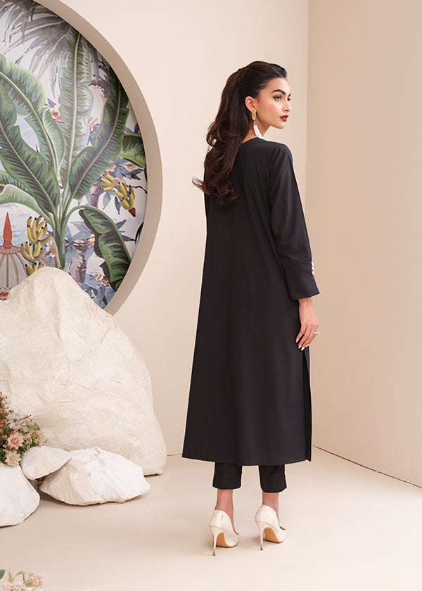 Black onyx crepe suit with white loop-button detailing and straight pants