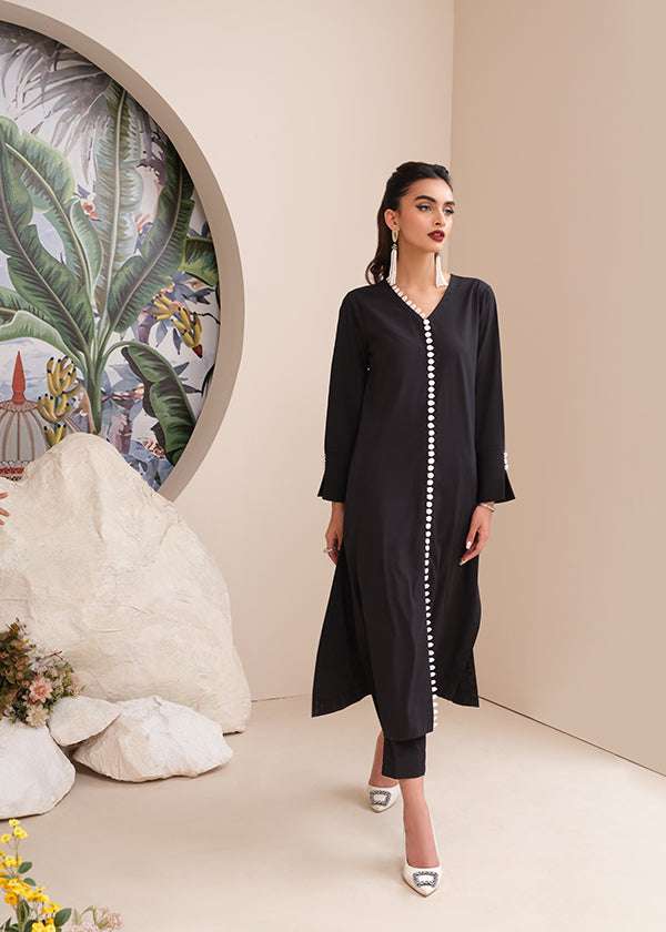 Black onyx crepe suit with white loop-button detailing and straight pants