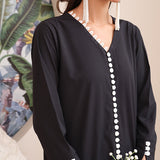 Black onyx crepe suit with white loop-button detailing and straight pants