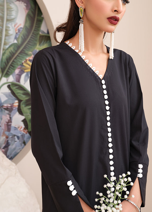 Black onyx crepe suit with white loop-button detailing and straight pants