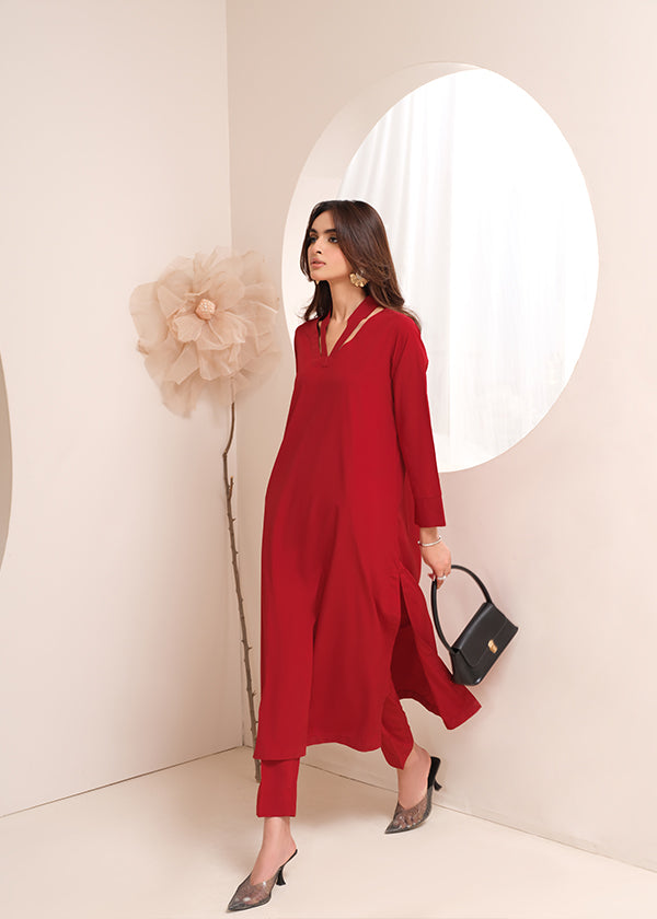 Crimson crepe suit with V-neck and minimalist stitching, exuding understated luxury.